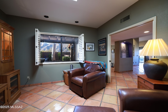 living area featuring light tile patterned flooring, visible vents, and baseboards