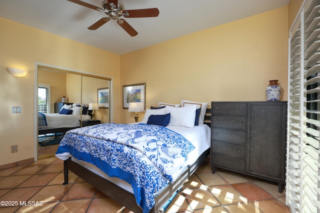 tiled bedroom featuring a closet, a ceiling fan, and baseboards