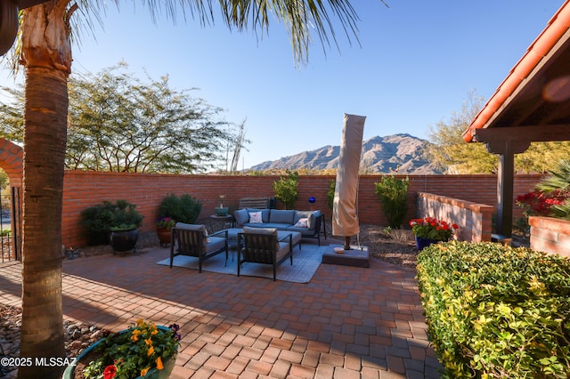 view of patio / terrace featuring a fenced backyard, a mountain view, and outdoor lounge area