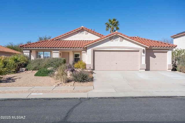 mediterranean / spanish-style home featuring a garage, driveway, a tiled roof, and stucco siding