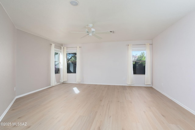 empty room with baseboards, a ceiling fan, and light wood-style floors