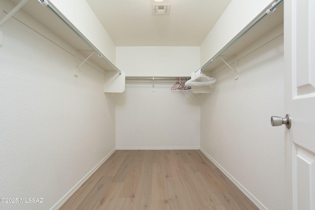 walk in closet with light wood finished floors and visible vents