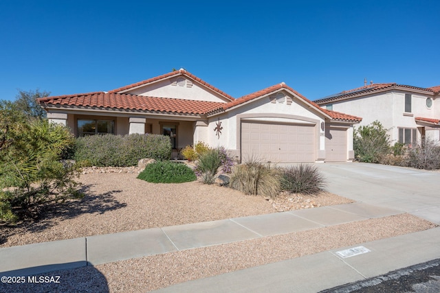 mediterranean / spanish home with a garage, a tile roof, concrete driveway, and stucco siding