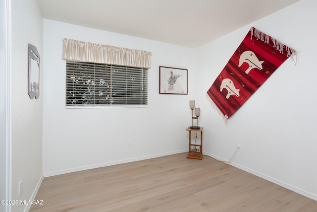 spare room featuring wood finished floors and baseboards