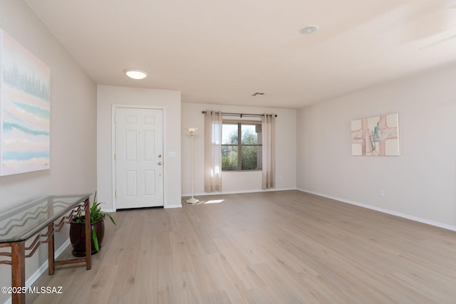 interior space featuring light wood-style floors, baseboards, and visible vents