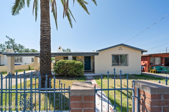 view of front of home with a fenced front yard, a gate, and stucco siding