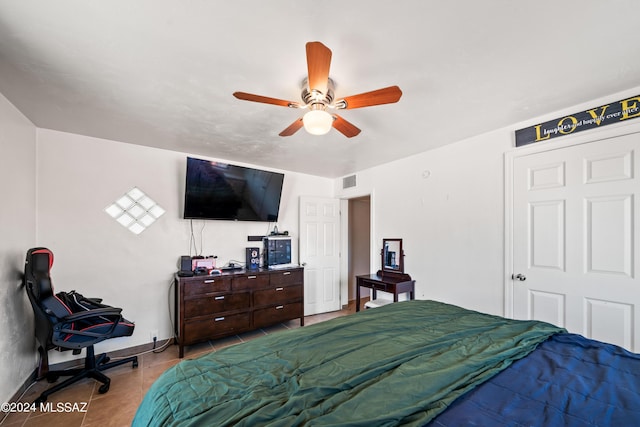 bedroom with tile patterned flooring, visible vents, ceiling fan, and baseboards