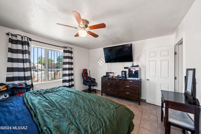 tiled bedroom featuring ceiling fan, visible vents, and baseboards