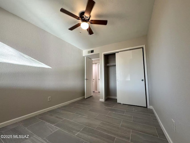 unfurnished bedroom featuring a ceiling fan, a closet, visible vents, and baseboards