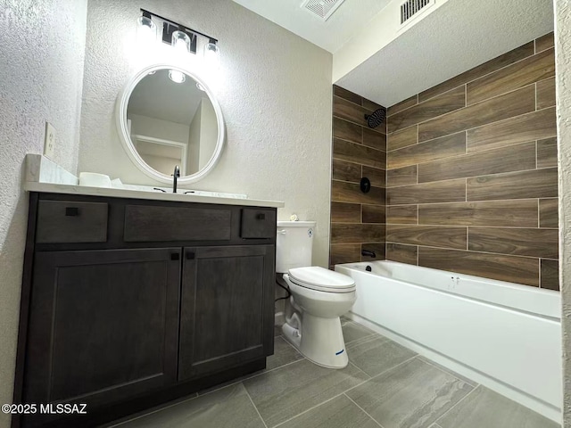 bathroom with toilet, visible vents, and a textured wall