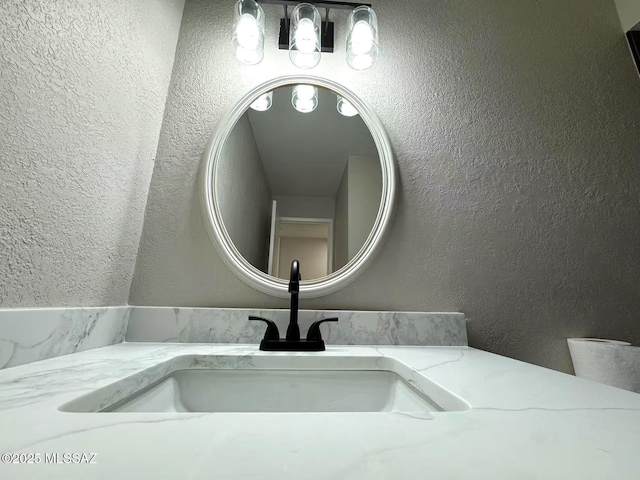 interior details with a textured wall and vanity