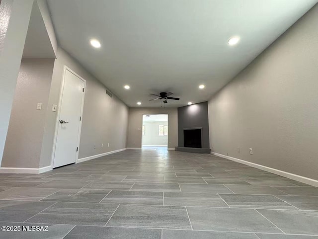 unfurnished living room with ceiling fan, recessed lighting, and baseboards