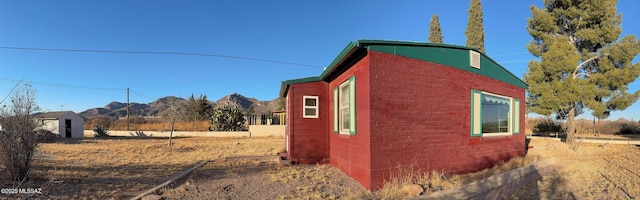 view of side of home with concrete block siding and a mountain view