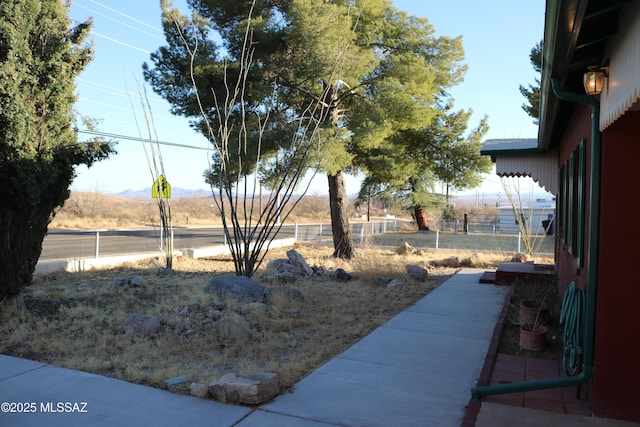 view of yard featuring fence and a mountain view