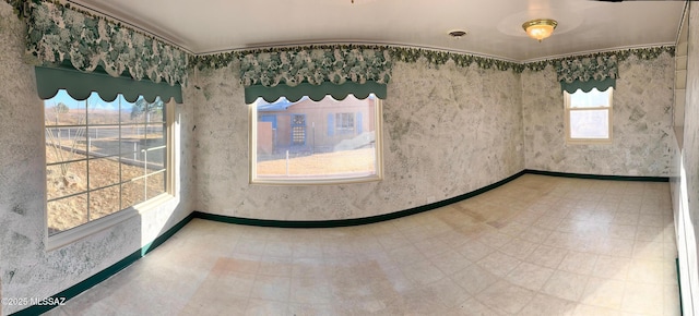 empty room with baseboards and tile patterned floors