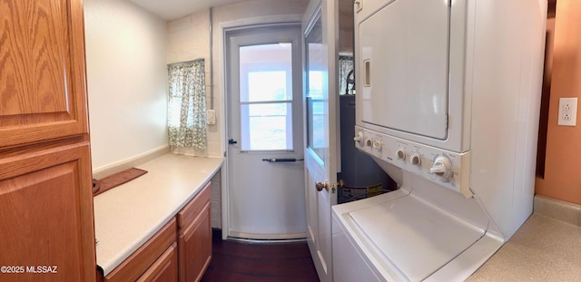 clothes washing area featuring stacked washer and clothes dryer