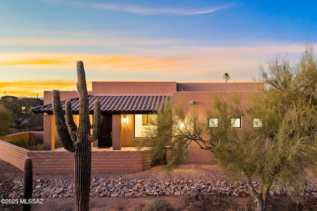 pueblo-style home featuring a patio area and stucco siding