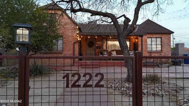 view of front of property featuring a fenced front yard and brick siding