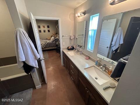 bathroom featuring double vanity, ensuite bath, and a sink