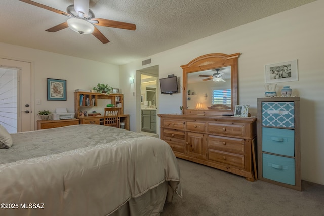 bedroom with visible vents, light colored carpet, ensuite bath, ceiling fan, and a textured ceiling