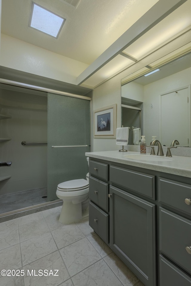 bathroom featuring marble finish floor, a shower with door, vanity, and toilet