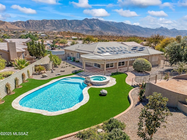 view of swimming pool with a pool with connected hot tub, a patio area, a fenced backyard, and a mountain view