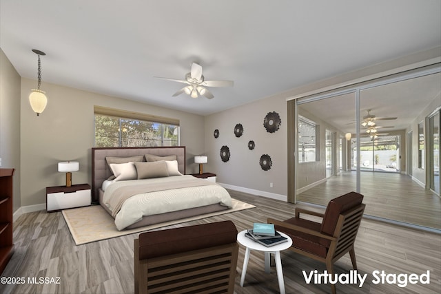 bedroom with multiple windows, light wood-type flooring, and baseboards