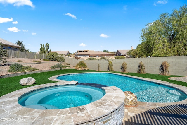 view of swimming pool featuring a pool with connected hot tub and a fenced backyard