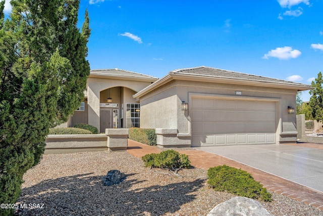 prairie-style home featuring driveway, an attached garage, and stucco siding