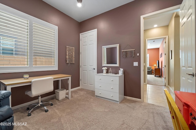 home office featuring baseboards, light tile patterned floors, and light carpet