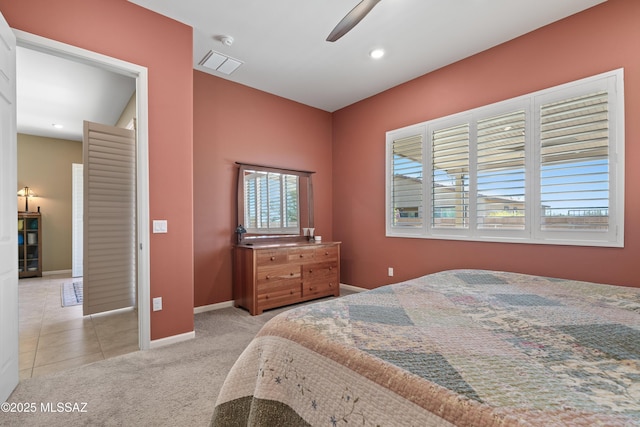 bedroom with light tile patterned flooring, visible vents, baseboards, a ceiling fan, and light carpet