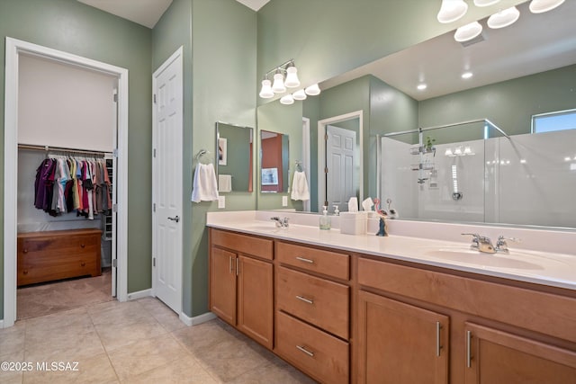 bathroom with double vanity, a stall shower, a sink, and tile patterned floors