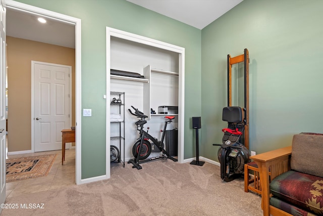 workout area featuring baseboards and carpet