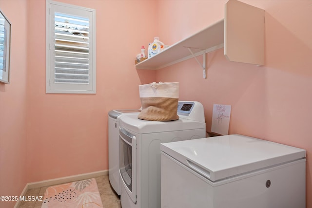 laundry area featuring laundry area, baseboards, washing machine and clothes dryer, and light tile patterned flooring