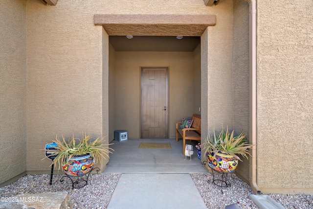 entrance to property with stucco siding