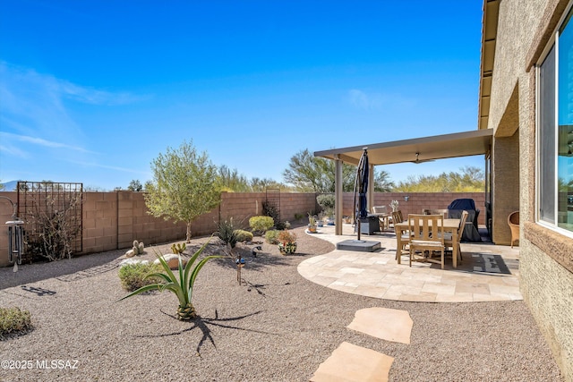 view of yard featuring a fenced backyard, outdoor dining space, and a patio
