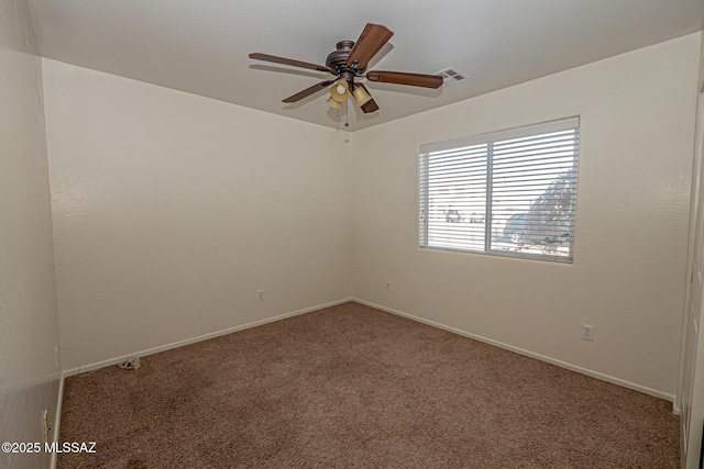 empty room featuring carpet floors, visible vents, baseboards, and a ceiling fan