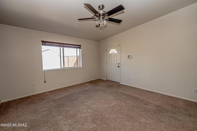 spare room featuring lofted ceiling, carpet, baseboards, and ceiling fan