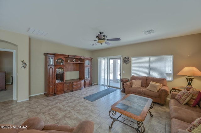 living area featuring baseboards, visible vents, and a ceiling fan