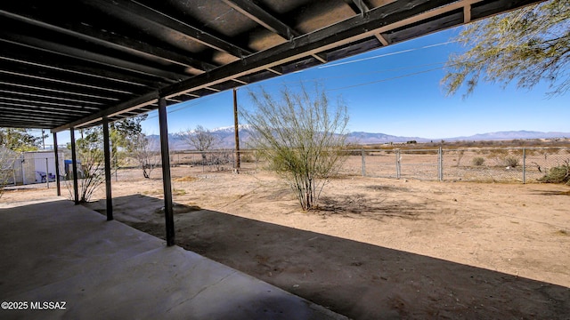 view of patio / terrace with a mountain view and fence