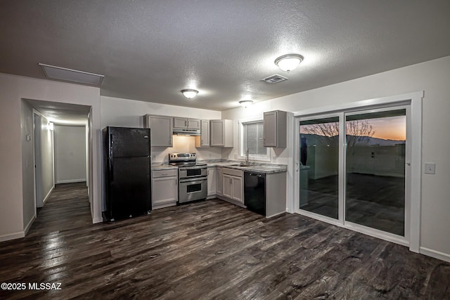 kitchen featuring gray cabinets, black appliances, light countertops, dark wood-type flooring, and under cabinet range hood