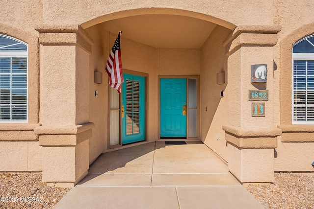 doorway to property featuring stucco siding