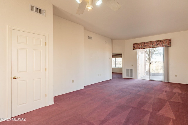 carpeted spare room with visible vents and a ceiling fan