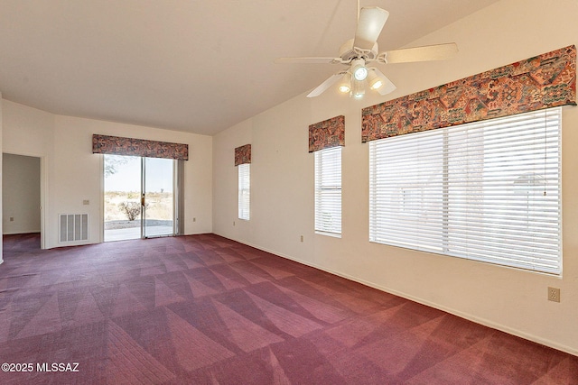 unfurnished room with lofted ceiling, dark carpet, visible vents, and a ceiling fan