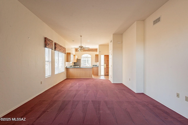 interior space with ceiling fan, carpet, visible vents, and baseboards