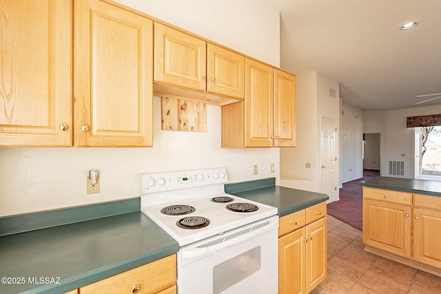 kitchen with white electric stove, light tile patterned floors, dark countertops, visible vents, and light brown cabinetry