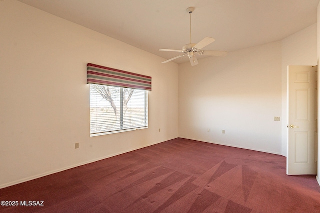 carpeted empty room featuring lofted ceiling, a ceiling fan, and baseboards