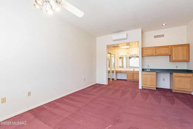 kitchen featuring baseboards, visible vents, dark colored carpet, and a wall mounted air conditioner