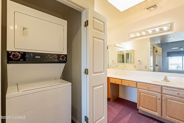 interior space featuring vanity, visible vents, and stacked washer and clothes dryer