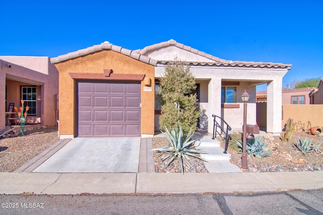 view of front of home with a garage, driveway, a tiled roof, and stucco siding